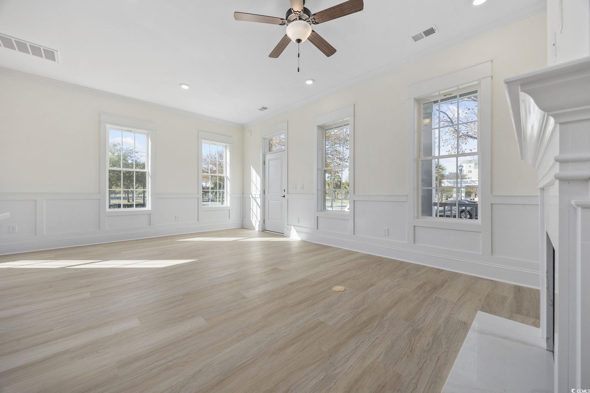 965 Hackler Street, Unit E Myrtle Beach, SC 29577 - Photo 4 of 36 Unfurnished living room with light wood finished floors, wainscoting, a ceiling fan, ornamental molding, and recessed lighting