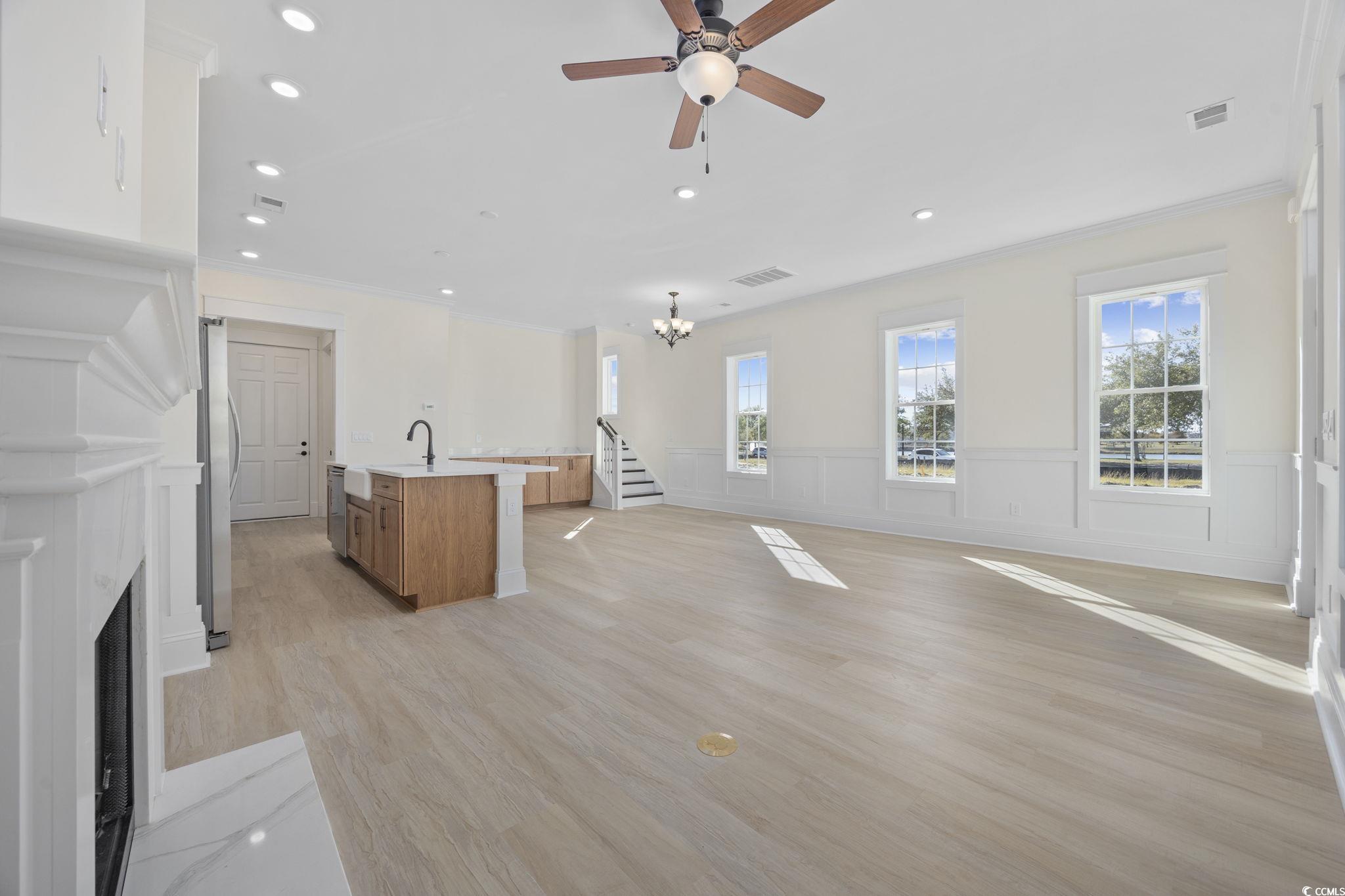 965 Hackler Street, Unit E Myrtle Beach, SC 29577 - Photo 5 of 36 Unfurnished living room featuring light wood-style flooring, recessed lighting, a chandelier, a fireplace with flush hearth, and a ceiling fan
