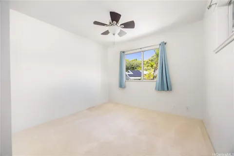 an empty room with window and ceiling fan