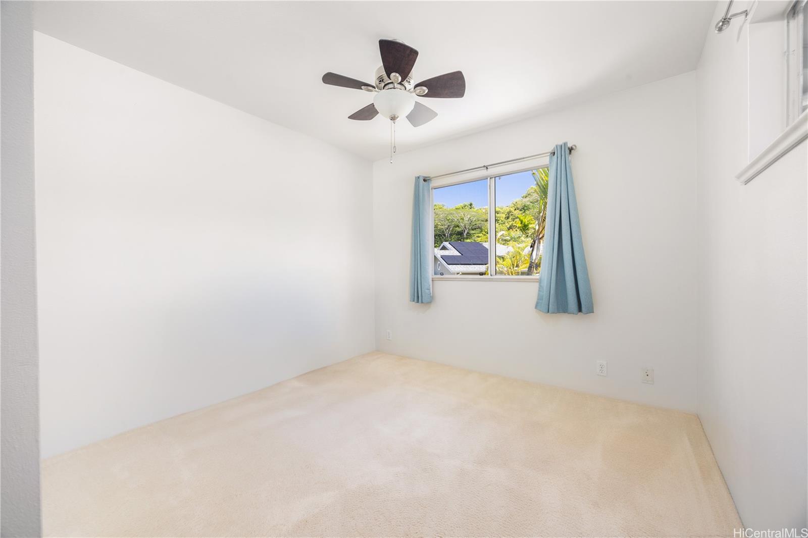 95-971 Wikao Street, Unit 11 Mililani, HI 96789 - Photo 19 of 24 an empty room with window and ceiling fan