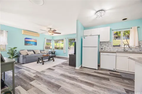 a living room with furniture and a refrigerator