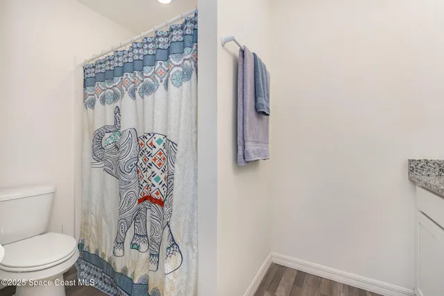 a bathroom with a toilet and a shower curtain