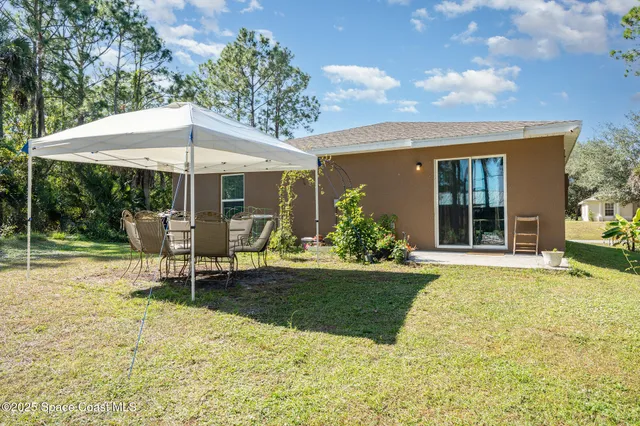 a view of a house with backyard porch and sitting area