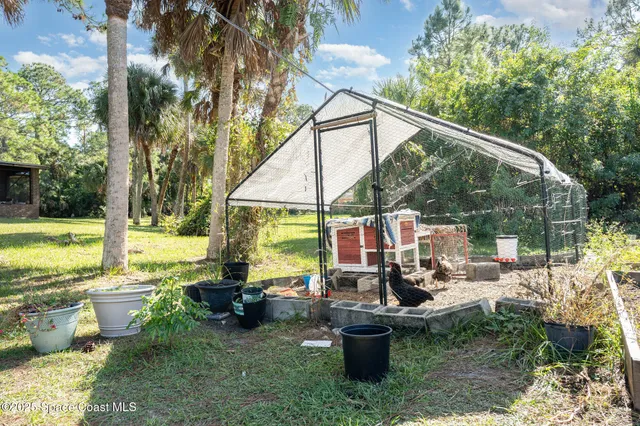 a view of a chair and tables in the patio next to a yard