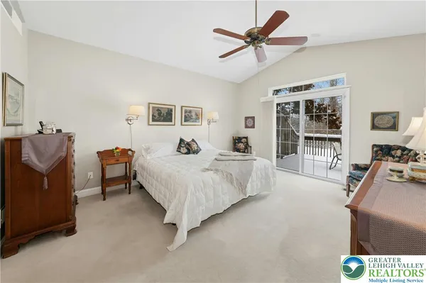 a spacious bedroom with a bed a couch and a chandelier