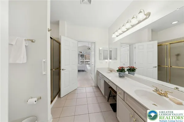 a bathroom with a double vanity sink a mirror and a shower