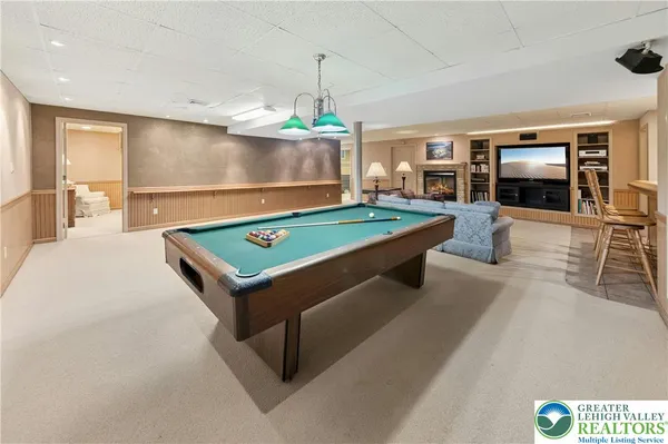 a room with pool table flat screen tv and windows