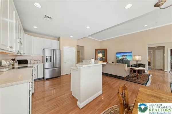 a living room with stainless steel appliances furniture refrigerator and a counter top space