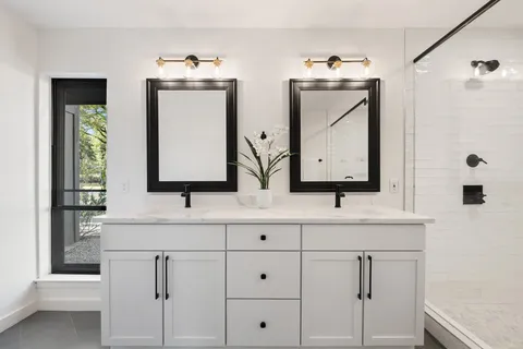 a bathroom with double vanity sink and mirror
