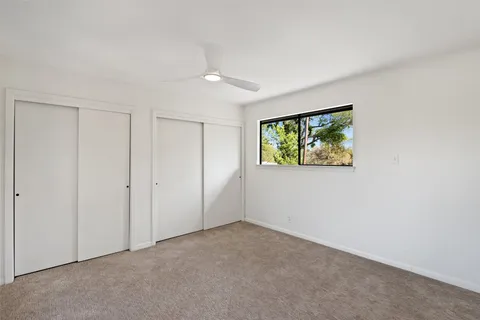 an empty room with windows and closet