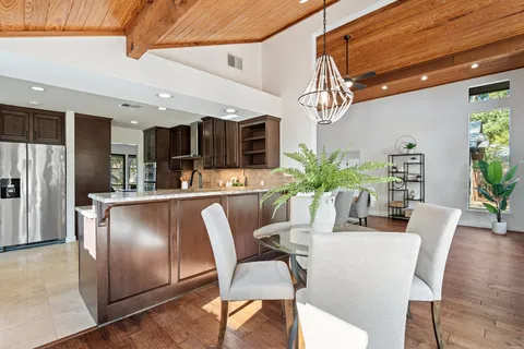 a dining room with furniture potted plants and wooden floor