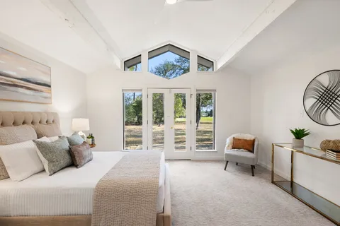 a bedroom with furniture and a large window