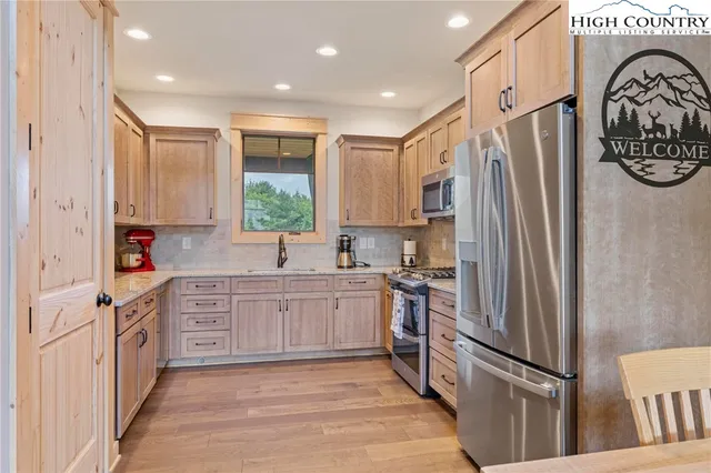 a kitchen with stainless steel appliances granite countertop a refrigerator sink and stove