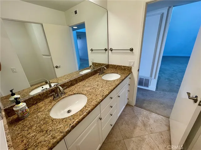 a spacious bathroom with a granite countertop sink and a mirror