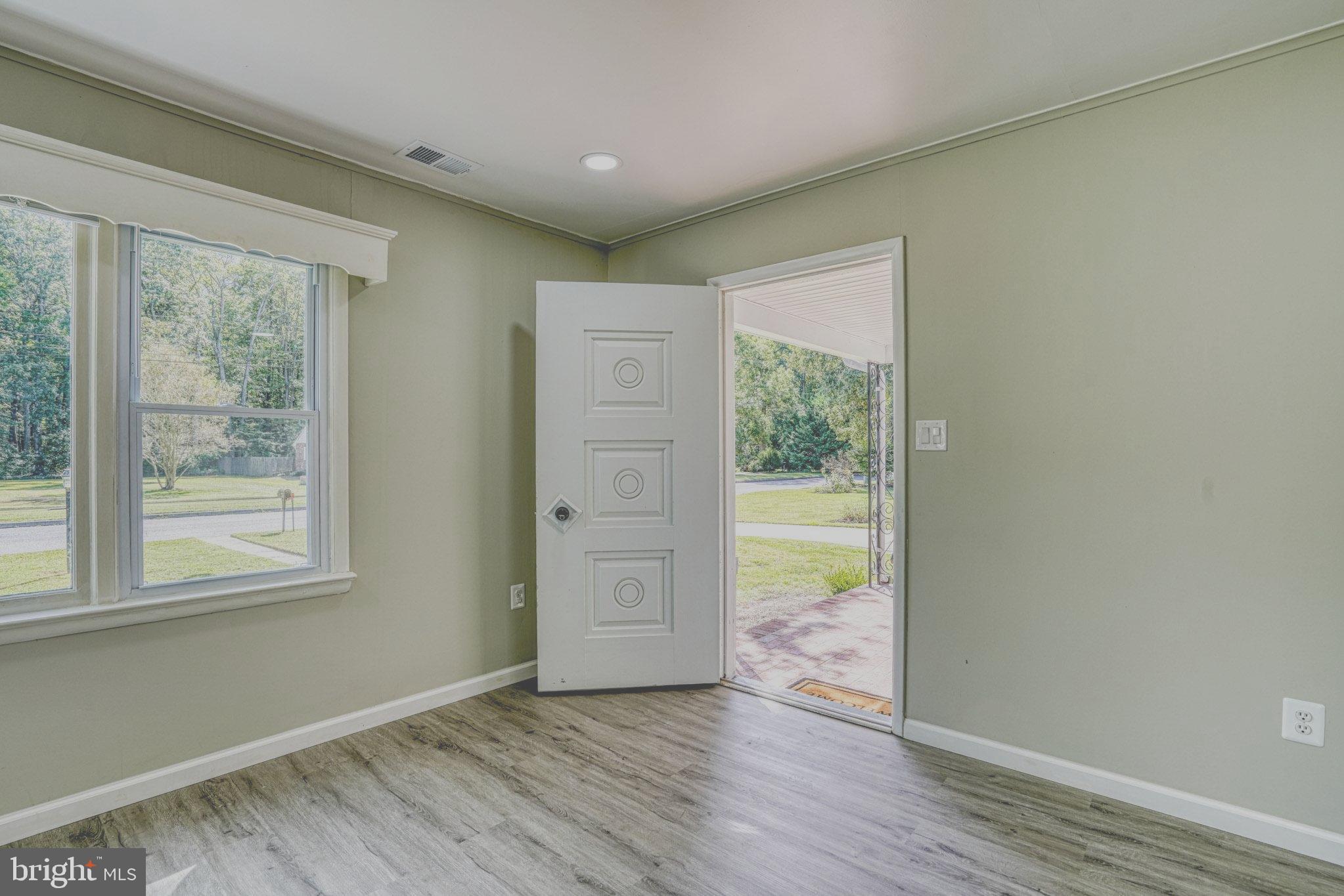 607 Edlon Park Cambridge, MD 21613 - Photo 15 of 34 an empty room with wooden floor and windows