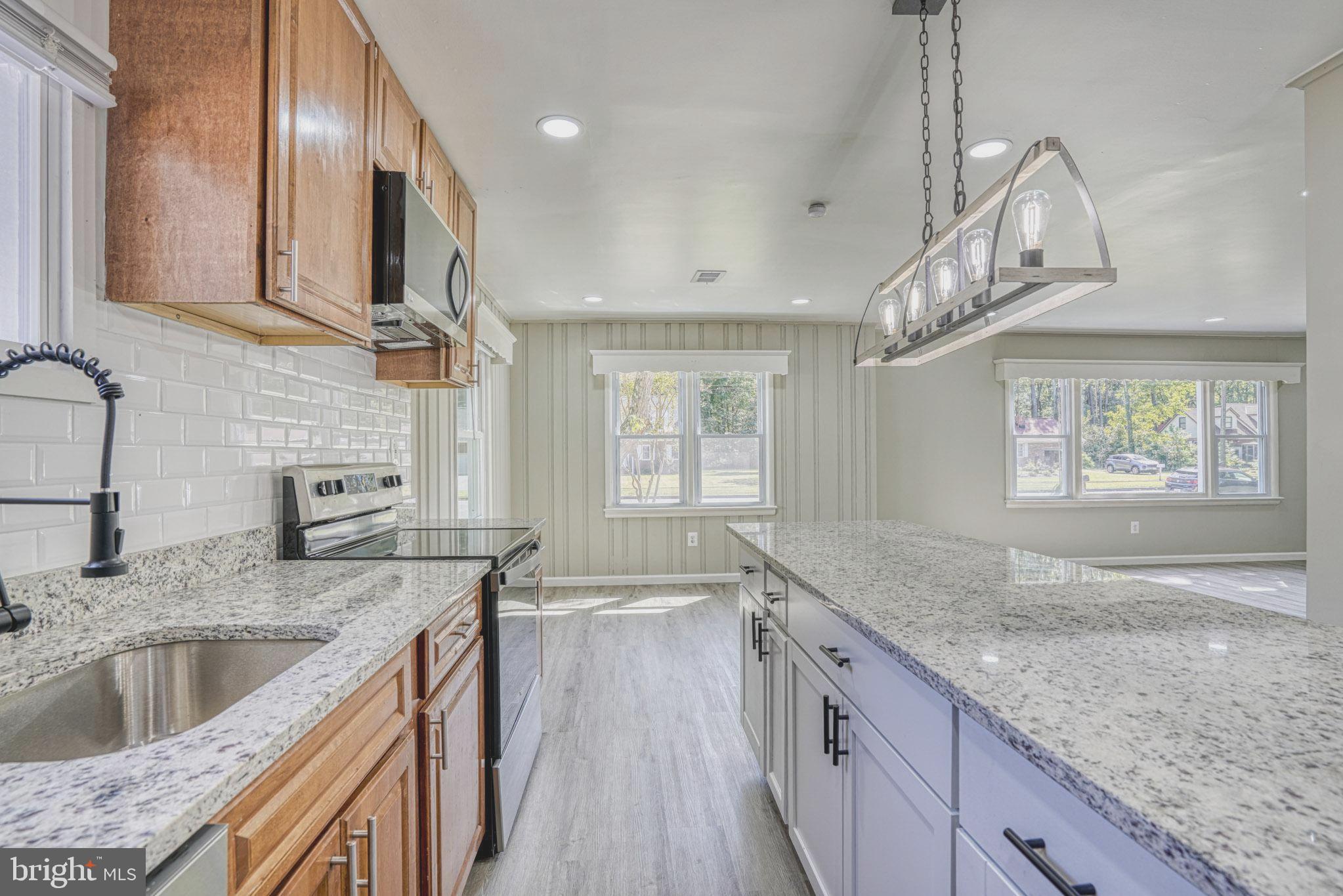 607 Edlon Park Cambridge, MD 21613 - Photo 18 of 34 a kitchen with stainless steel appliances granite countertop a sink a stove and a wooden floors