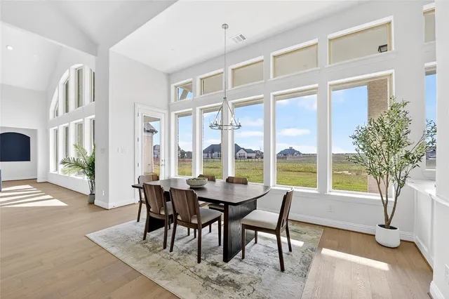 a dining room with furniture large windows and a chandelier