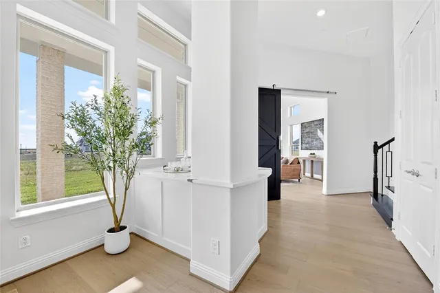 a view of a hallway with windows and chandelier
