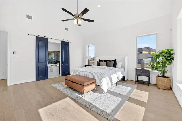 a bedroom with a large bed and a chandelier