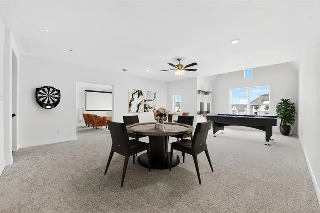 a view of a dining room and livingroom with furniture wooden floor a rug a flat screen tv
