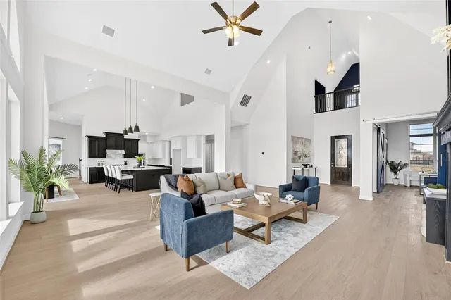 a living room with furniture kitchen view and a large window