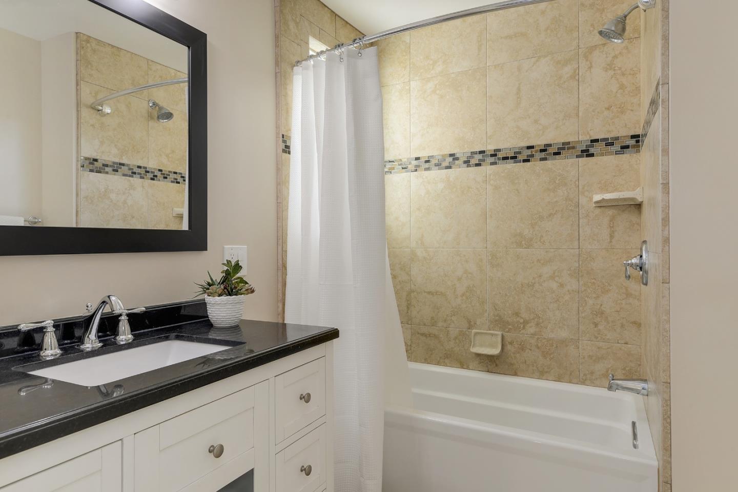 22620 Ricardo Road Cupertino, CA 95014 - Photo 20 of 34 a bathroom with a granite countertop sink a mirror a vanity and a bathtub