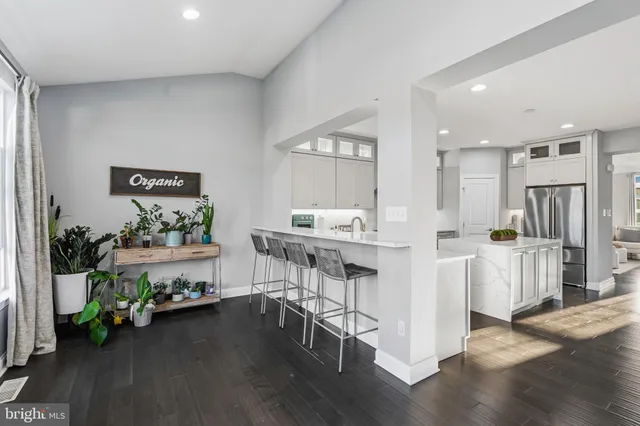 a kitchen with kitchen island white cabinets and wooden floor