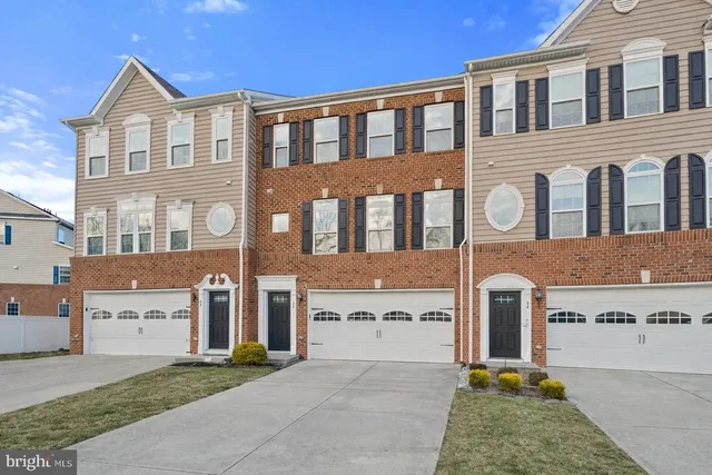a front view of a house with yard and parking
