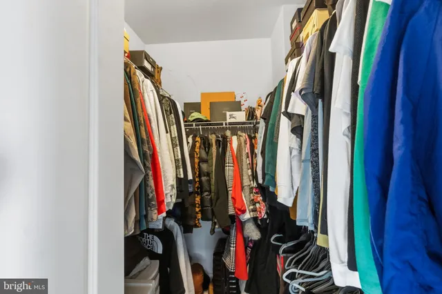 a view of walk in closet with clothes