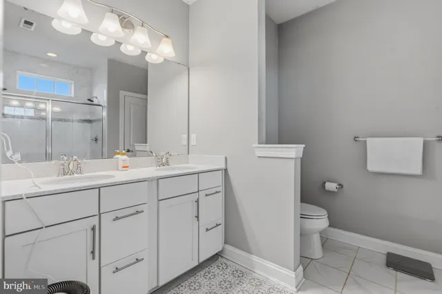 a bathroom with a double vanity sink and a toilet