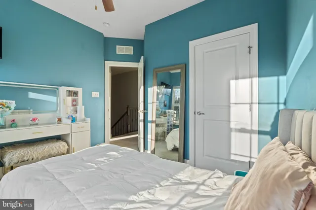 a bedroom with a bed and a dresser with wooden floor