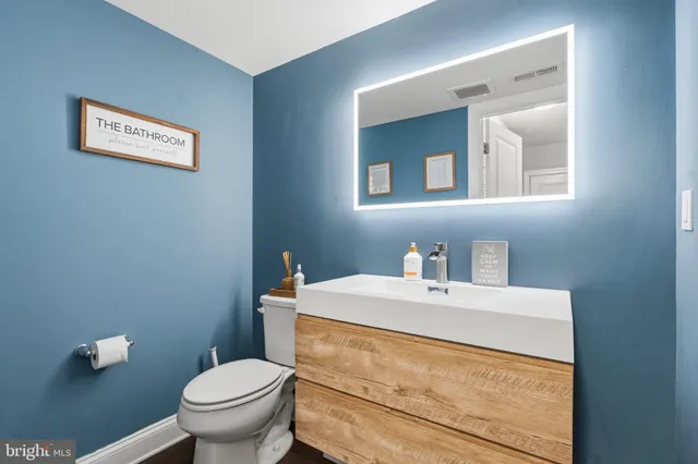 a bathroom with a sink vanity mirror and toilet