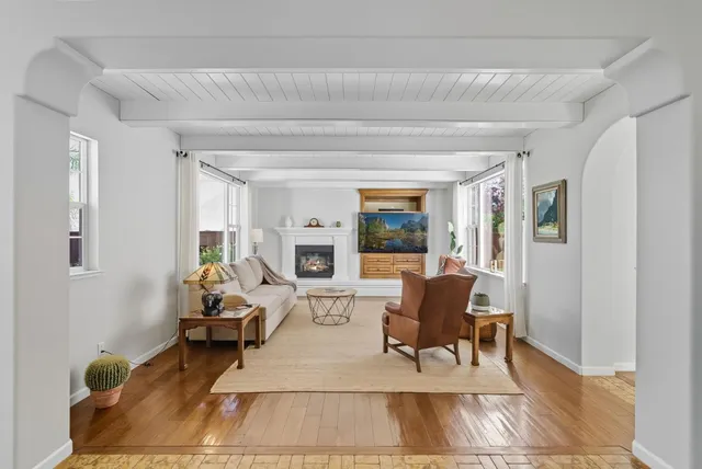 a living room with furniture and a dining table with rug