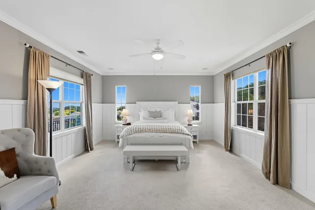 a spacious bedroom with a bed couch and a large window