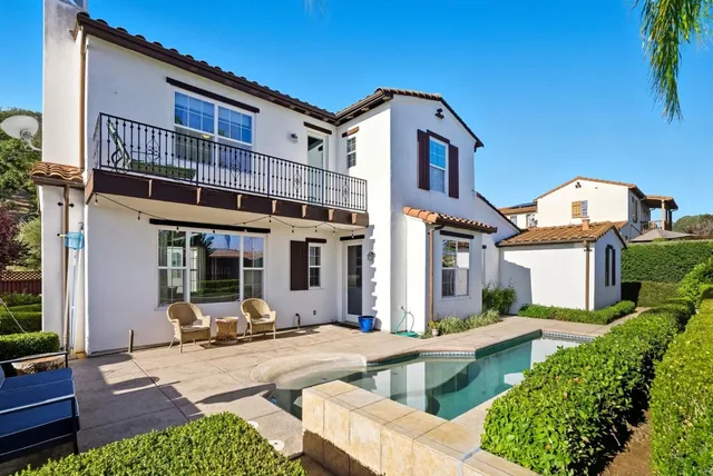 a front view of a house with swimming pool and furniture