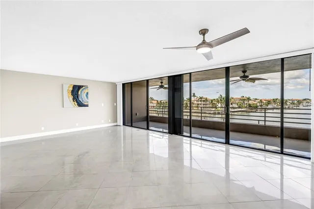 an empty room with windows and entrance to other room