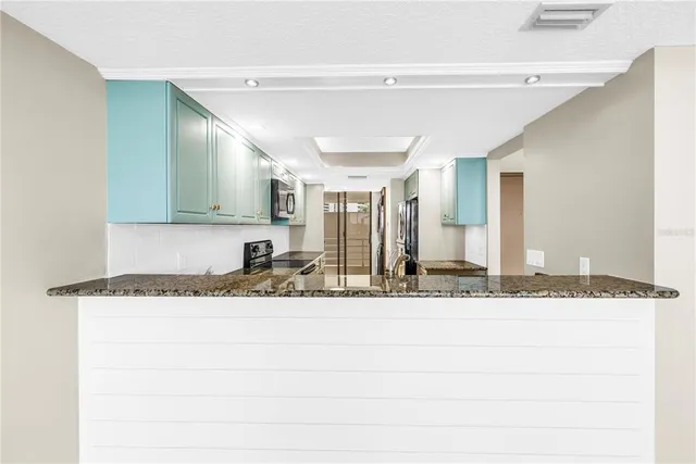 a kitchen with stainless steel appliances granite countertop a stove top oven a sink dishwasher and a refrigerator