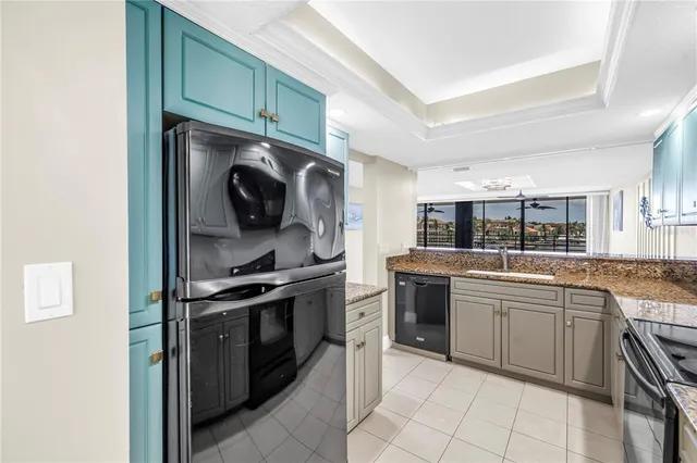 an empty room with chandelier fan and windows