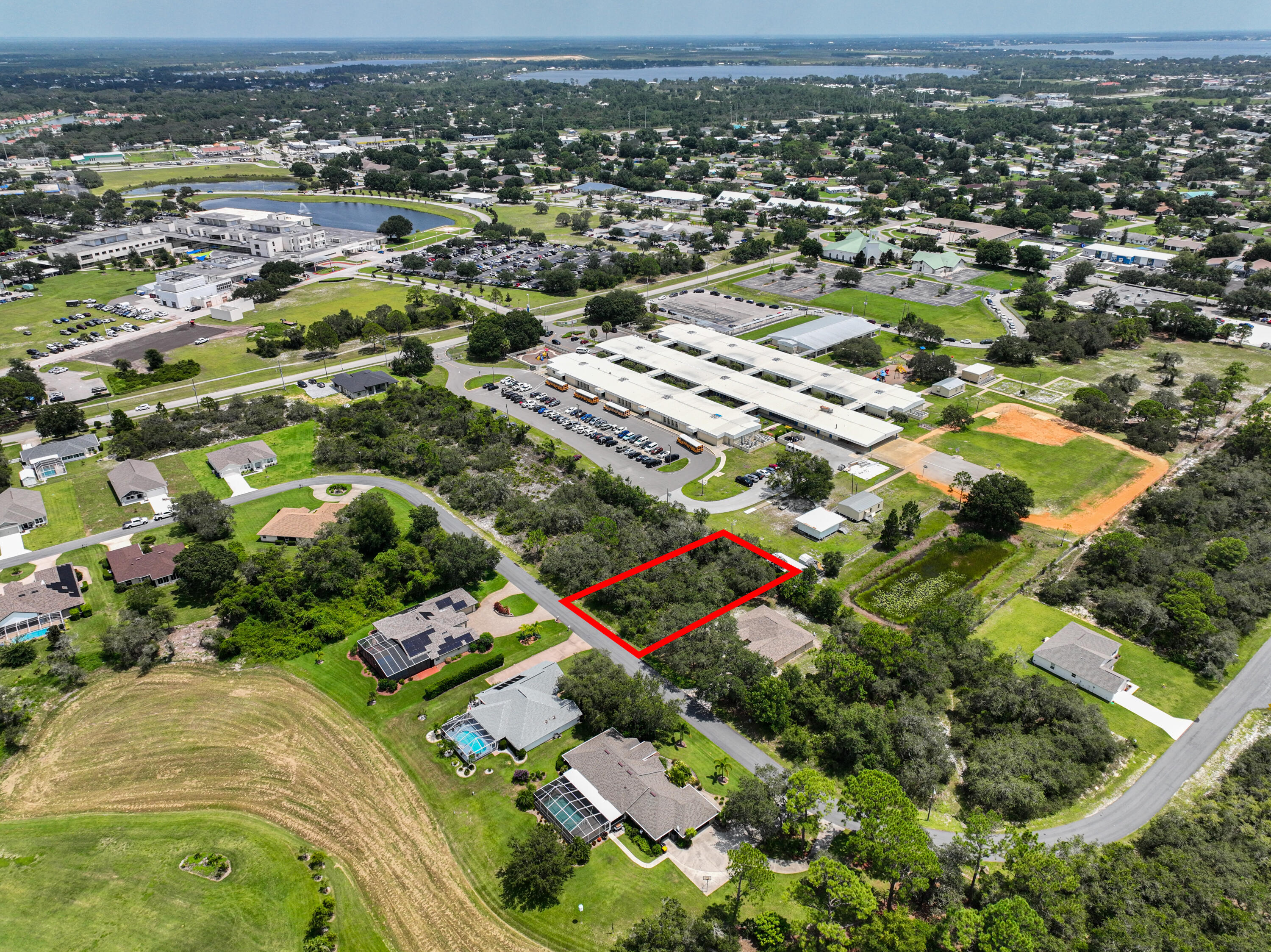 an aerial view of residential houses with outdoor space and trees