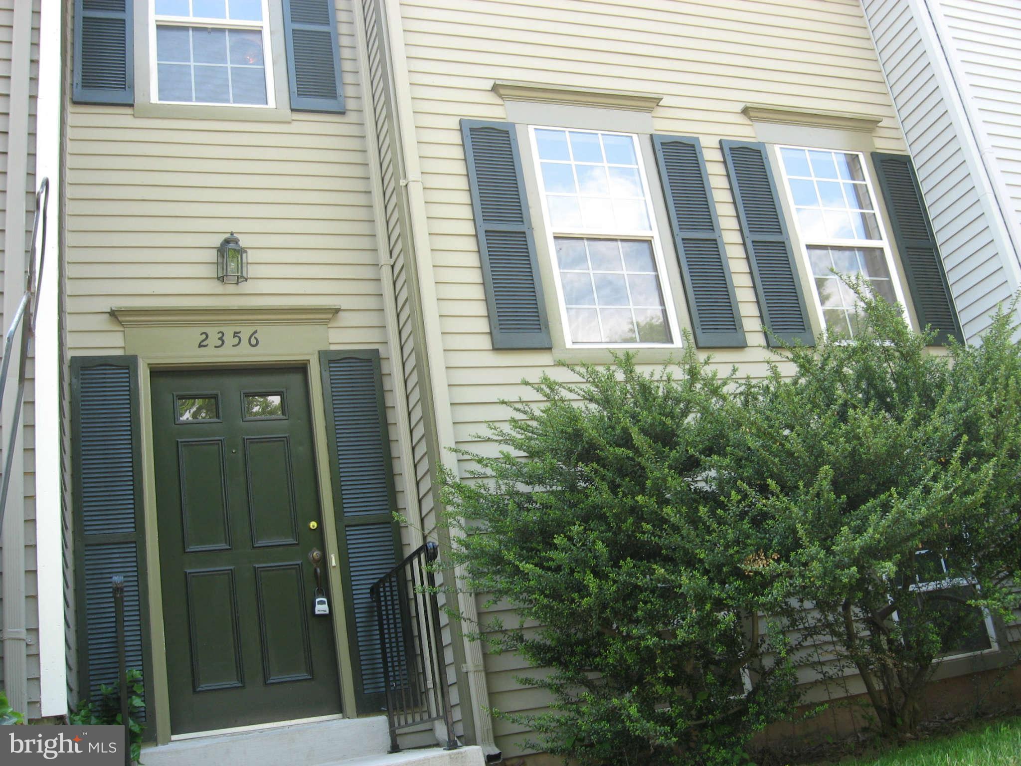2356 Hunters Square Court, Unit 2356 Reston, VA 20191 - Photo 2 of 27 a view of a brick house with a large window and wooden fence