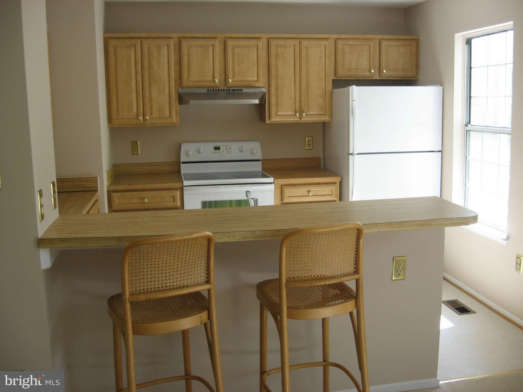 2356 Hunters Square Court, Unit 2356 Reston, VA 20191 - Photo 13 of 27 a kitchen with a refrigerator and cabinets