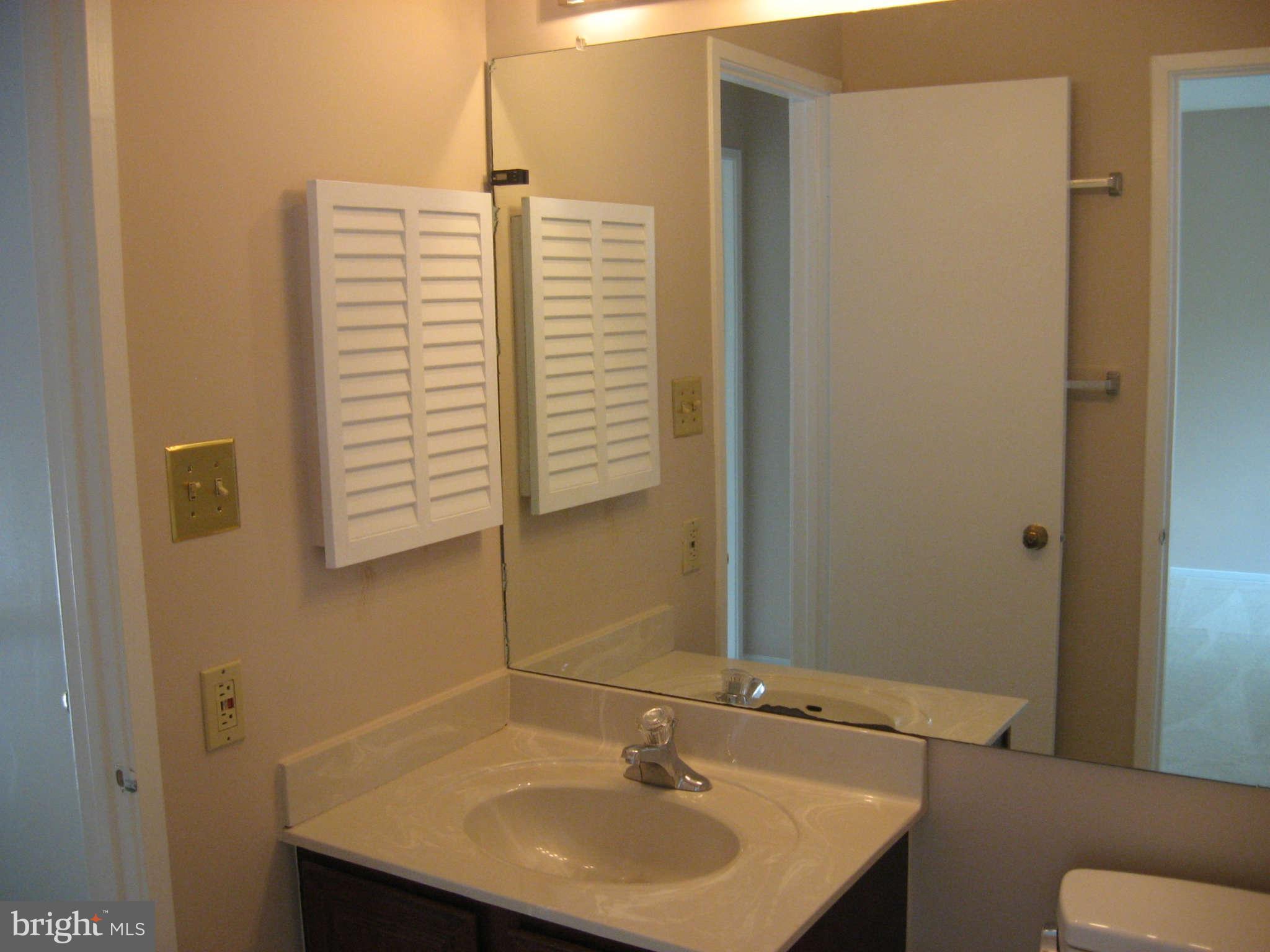 2356 Hunters Square Court, Unit 2356 Reston, VA 20191 - Photo 17 of 27 a bathroom with a sink and a mirror