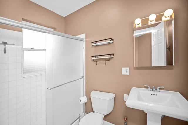 a bathroom with a sink mirror and toilet