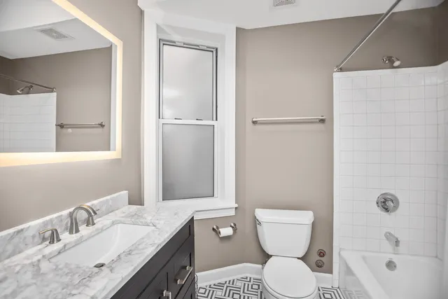 a bathroom with a granite countertop toilet a sink and a bathtub
