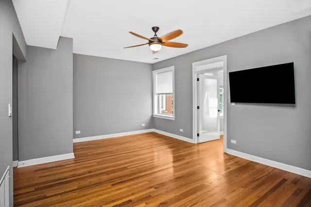 a view of a livingroom with wooden floor and a ceiling fan