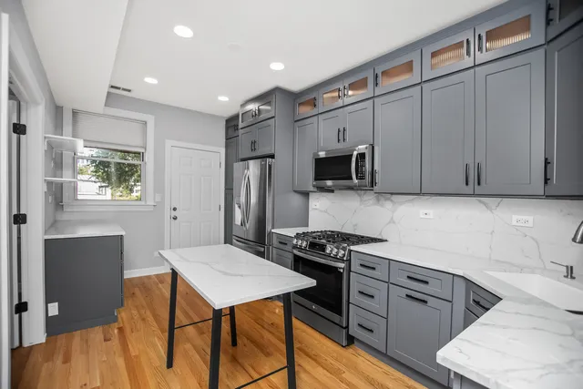 a kitchen with stainless steel appliances a stove refrigerator sink and cabinets