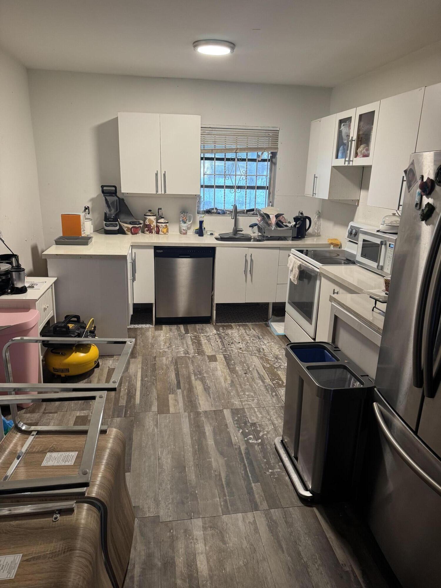 1017 Northwest 47th Street Miami, FL 33127 - Photo 3 of 18 a kitchen with a sink appliances and cabinets