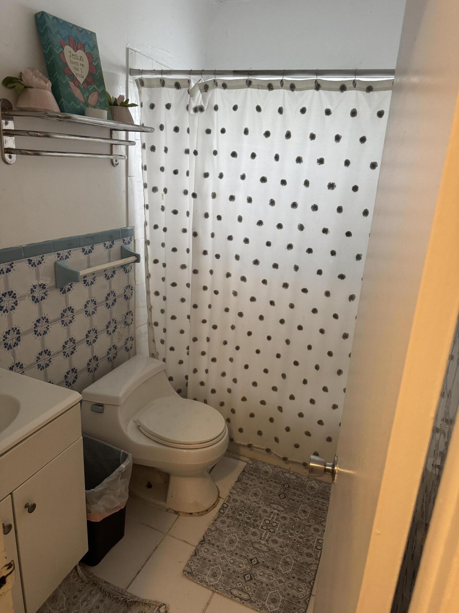 1017 Northwest 47th Street Miami, FL 33127 - Photo 7 of 18 a white toilet sitting next to a shower curtain