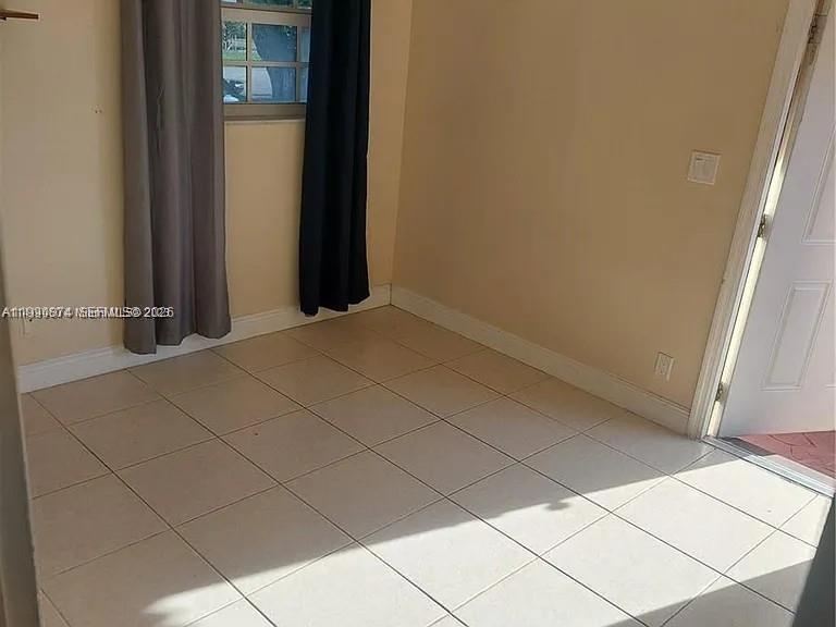 6117 Southwest 31st Street, Unit B Miramar, FL 33023 - Photo 4 of 8 a view of an empty room and a window
