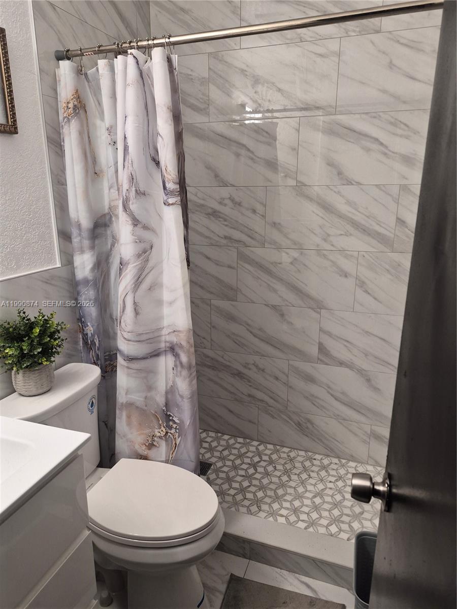 6117 Southwest 31st Street, Unit B Miramar, FL 33023 - Photo 6 of 8 a bathroom with a toilet and a shower